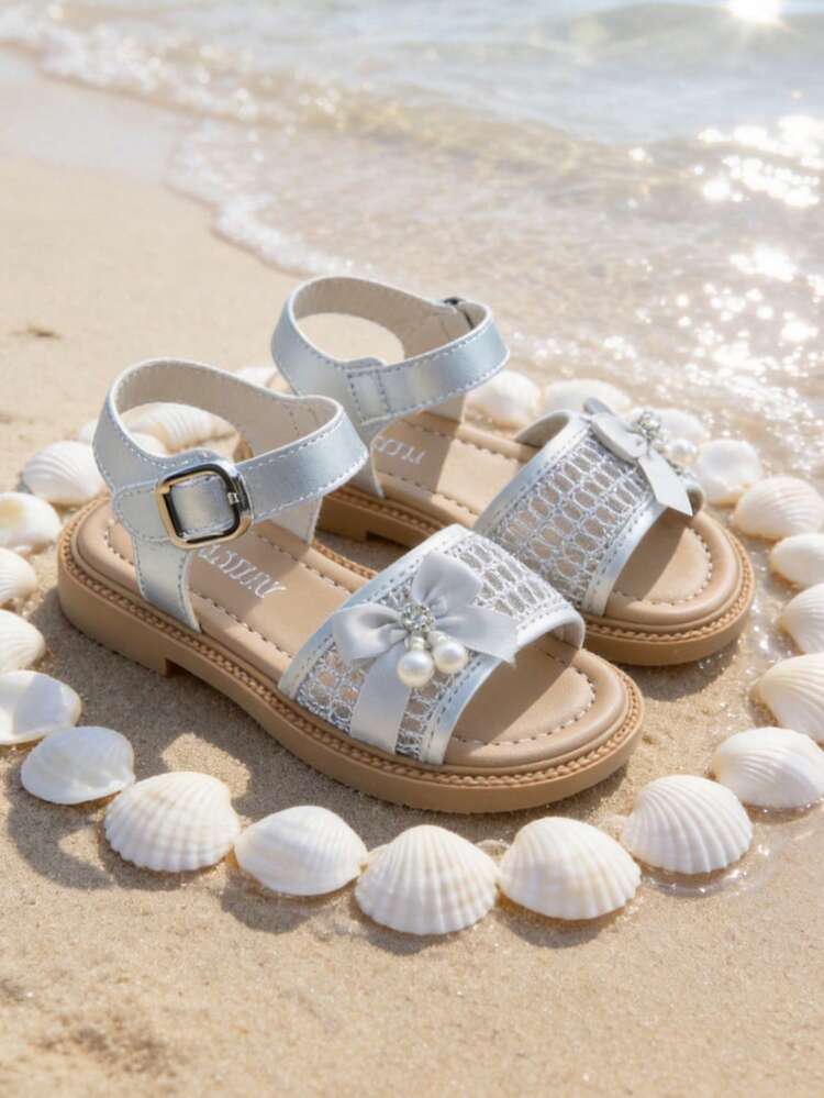 Bán chạy nhất - Sandal bạc cho trẻ em từ 3-12 tuổi. Thêu nơ + Mặt dây chuyền ngọc trai pha lê. Thiết kế móc và vòng dễ xỏ/tháo. Đế cao su mềm màu nâu nhạt. Phong cách kỳ nghỉ nhẹ nhàng như tiên nữ. Phù hợp với váy công chúa, chân váy xếp ly, quần jean, quần short và các trang phục mặc hàng ngày khác. - Bạc - Xem 4