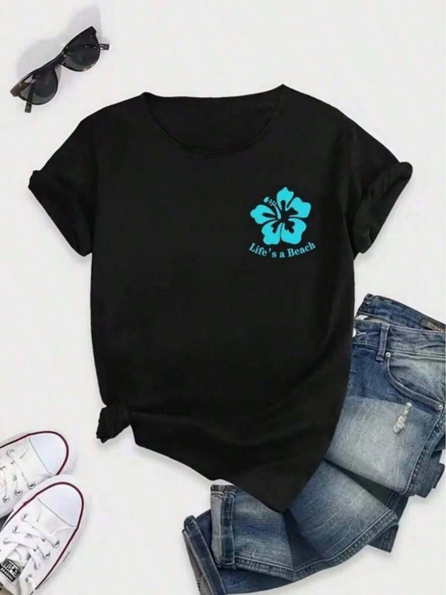 Camiseta de mujer de talla grande, manga corta, con estampado gráfico de hibisco turquesa y el eslogan "La vida es una playa". - Negro - Ver 1
