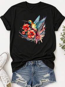 Camiseta Estampada para Mujer - Camiseta Casual Negra de Manga Corta y Cuello Redondo con Colorido Gráfico de Colibrí y Flores. Con un Corte Relajado para Todas las Estaciones, la Elección Perfecta Tanto para el Uso Diario como para tus Atuendos de Vacaciones (Lavable aáquina). - Negro - Ver 1