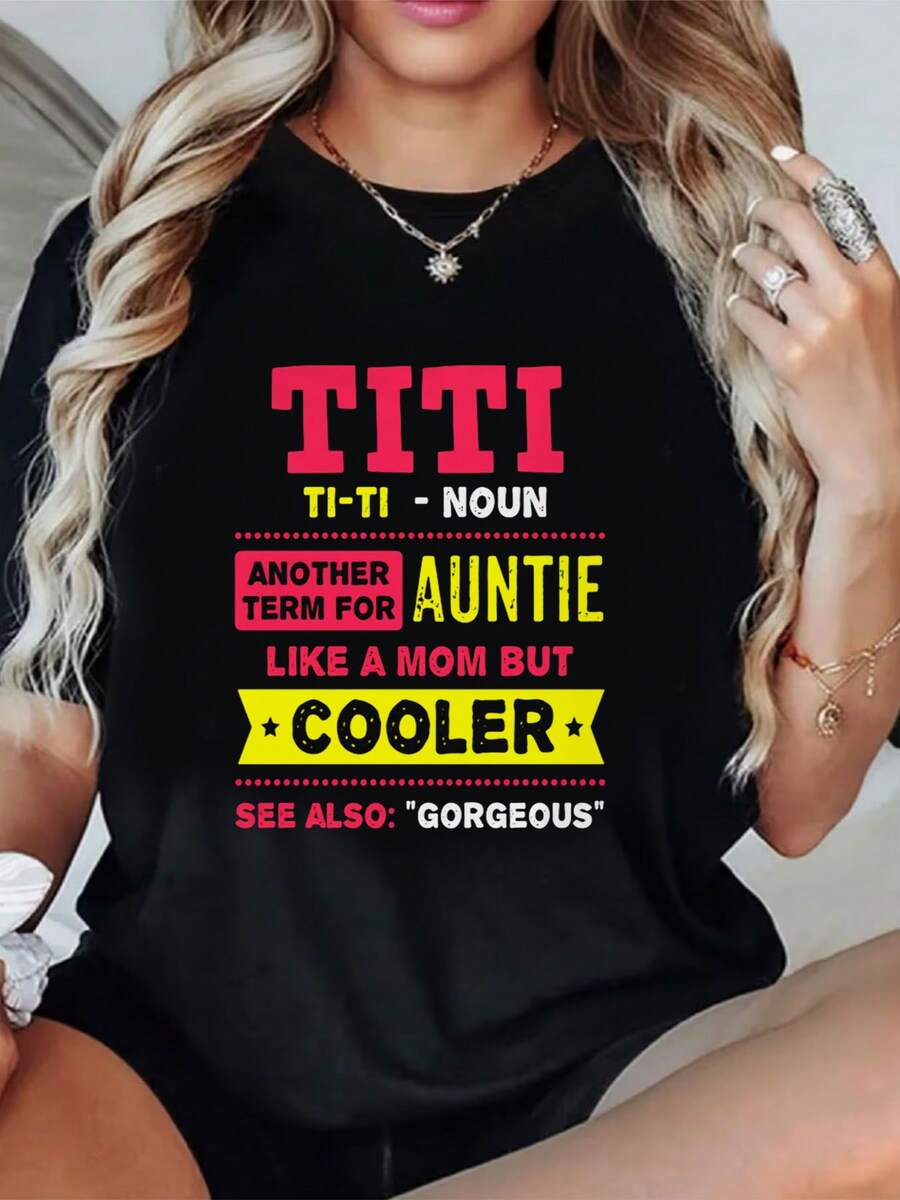 Una camiseta negra divertida y única con un llamativo texto rosa que dice "", un diseño amarillo juguetón con las palabras "TI - TI - NOUN", un texto amarillo que dice "Otro apodo para tía", un estampado de estrellas con las palabras "Como una madre, pero más genial" impresas en ella, una prenda femenina tricolor. - Negro - Ver 1