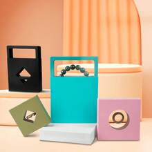 A Transparent Film Suspended Jewelry Packaging Display Box, Available In Multiple Colors, Includes A Matching Paper Outer Box. It Can Store Rings, Earrings, Bracelets, And Other Types Of Jewelry. Features Scratch-Resistant And Dust-Proof Design, Combining The Functions Of Store Display And Holiday Gift Packaging. A Simple And Practical Universal Jewelry Storage Box - White Film Box; 11*11 - View 4
