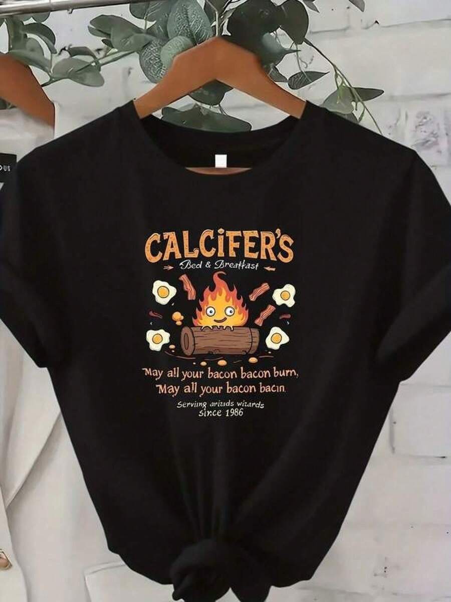 Playera de Algodón Puro Unisex Estampada CasualCamiseta única y original con diseño de Calcifer fuego y desayuno inspirado en la cultura pop y2k ideal para amantes del buen humor y la comida divertida, perfecta para destacar tu estilo único y divertido en cualquier ocasión.Cómoda y versátil para escuela, trabajo, salidas y eventos casuales - Negro - Ver 1
