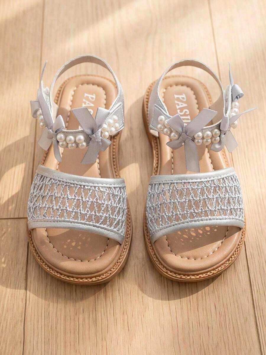 Bán chạy nhất - Sandal trẻ em 3-12 tuổi màu xám bạc. Phần trên làm bằng vải lưới màu xám bạc, đính kim tuyến. Trang trí bằng nơ ruy băng và ngọc trai hai hàng. Gót giày có thiết kế dán xé dễ dàng xỏ vào và tháo ra. Đế cao su mềm màu nâu nhạt dạng phẳng. Phong cách công chúa tươi mới, phù hợp phối với váy công chúa, chân váy xếp ly, quần jean, quần short và các trang phục mặc hàng ngày khác. - Bạc - Xem 1