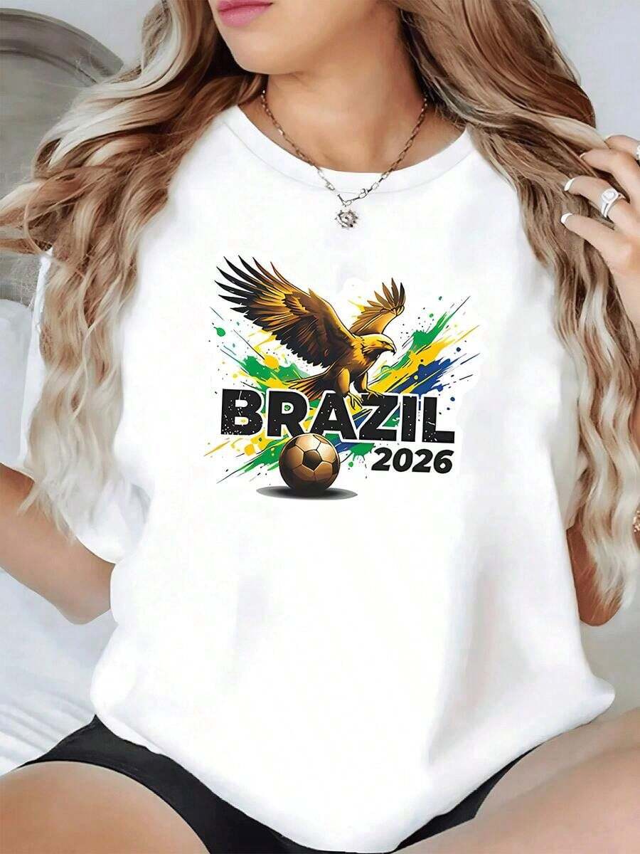 Águila dorada volando sobre un balón de fútbol con colores vibrantes verde azul y amarillo que evocan la energía de Brasil 2026 camiseta de mujer casual moderna y cómoda para amantes del deporte - Blanco - Ver 1