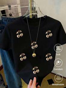 Camiseta negra para mujer con cerezas doradas brillantes, manga corta, cuello redondo, corte holgado, blusa casual cómoda - Negro - Ver 1