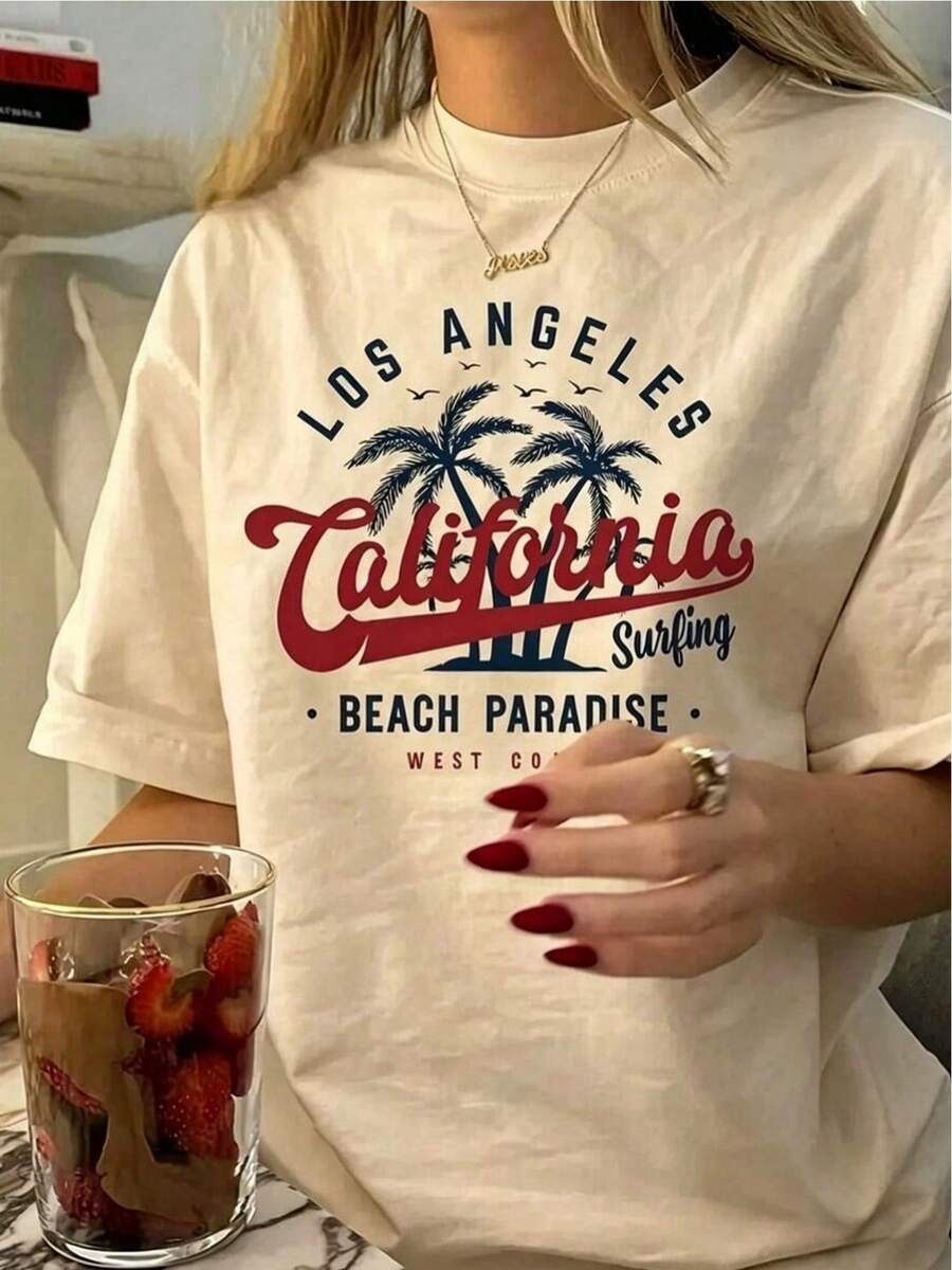 Camiseta de mujer con estampado de Los Ángeles, California, letras rojas estilo manuscrito con palmeras y el texto "Beach Paradise Surfing", impresión térmica de alta calidad, fondo estilo playa de verano. - Albaricoque - Ver 1