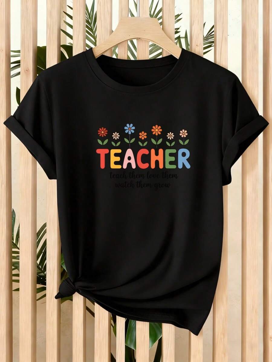 Camiseta de mujer, nuevo producto de verano, camiseta de manga corta para mujer con flores coloridas que rodean la palabra "PROFESORA", transmitiendo un cálido concepto educativo, adecuada para el hogar, la oficina y los viajes, una prenda versátil. - Negro - Ver 1