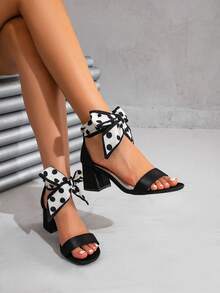 Sandalias de tacón grueso con punta cuadrada y lazo de satén a lunares, los talla grande vendidos del verano, hechas de material de satén delicado con textura de brillo suave, suaves y elegantes en los pies; el tacón grueso del mismo color proporciona un soporte estable, equilibrando el aumento de altura y la estabilidad al caminar, cómodas para uso prolongado. Ya sea para vacaciones, fiestas, citas o atuendos diarios, estos versátiles zapatos de verano mantienen fácilmente la vibra romántica. - Negro - Ver 1