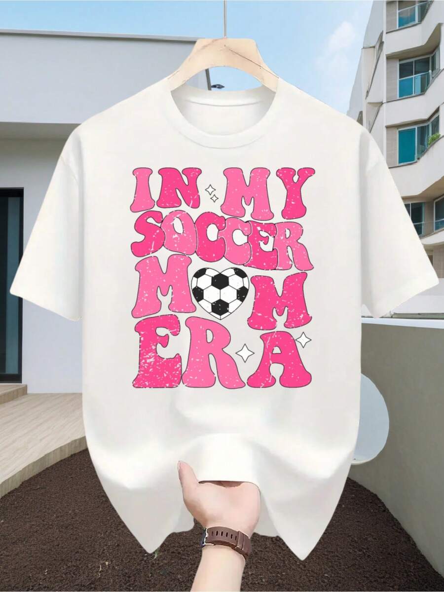Camiseta unisex, lavable a máquina, con temática vintage de "madre de futbolista", que presenta una fuente clásica en rosa desgastado y elementos de fútbol en forma de corazón, creando un ambiente nostálgico. Ya sea combinada con jeans vintage o pantalones cargo deportivos, puede crear un estilo deportivo dulce y moderno, convirtiéndola en un regalo de moda para las madres de futbolistas. - Blanco - Ver 1