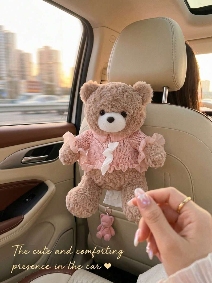 可爱小熊车载纸巾盒，适合悬挂在后排座椅头枕上——这款仪表盘纸巾盒设计可爱，小熊身穿粉色连衣裙和马甲，头戴蝴蝶结发带，配有悬挂式纸巾架。时尚的汽车内饰配件。