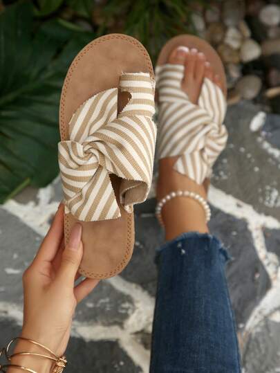 Dép xỏ ngón đế bằng kẻ sọc kaki và trắng cho nữ, quai ngang bằng da lộn trang trí nơ, kiểu dép đi biển thường ngày của ngư dân, hàng mới về mùa hè.