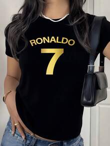 Muestra tu admiración por el legendario futbolista con esta camiseta de mujer blanca, luciendo orgullosamente el icónico número 7 dorado y el nombre RONALDO en letras doradas, un tributo a su legado deportivo, una prenda esencial para cualquier aficionada al fútbol moderno que busca combinar estilo y pasión por el deporte Rey. - Negro - Ver 1