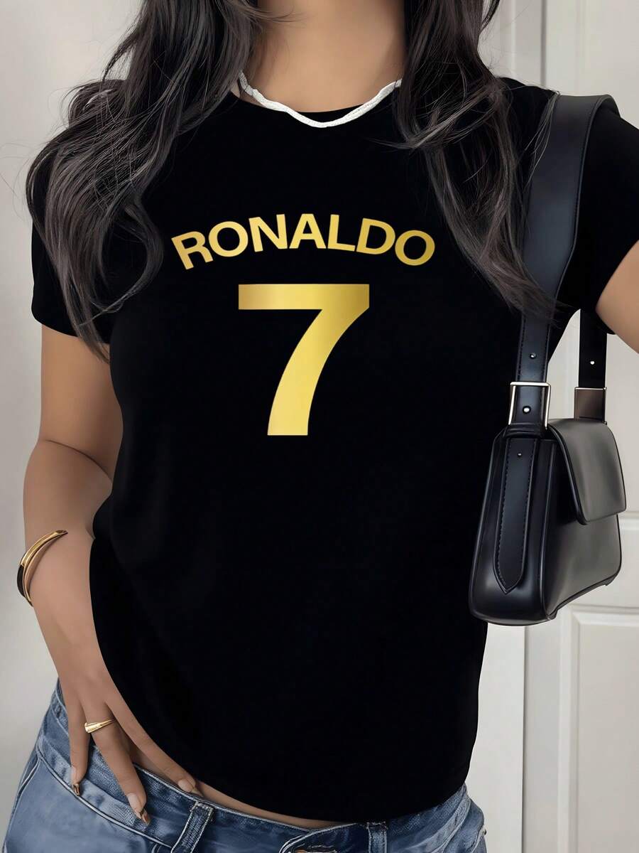 Muestra tu admiración por el legendario futbolista con esta camiseta de mujer blanca, luciendo orgullosamente el icónico número 7 dorado y el nombre RONALDO en letras doradas, un tributo a su legado deportivo, una prenda esencial para cualquier aficionada al fútbol moderno que busca combinar estilo y pasión por el deporte Rey. - Negro - Ver 1