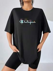El divertido y alegre logo de Champion cobra vida con un toque de naturaleza y optimismo, luciendo flores delicadas y un sol sonriente que irradia felicidad. Esta camiseta de mujer, confeccionada en, celebra la alegría de vivir y la belleza efímera. Perfecta para un look casual y vibrante, esta camiseta combina comodidad y un mensaje positivo para alegrar tu día a día. camiseta de mujer - Negro - Ver 6