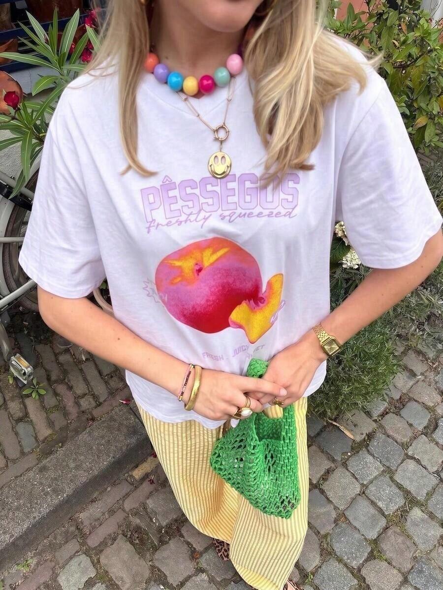 Camiseta Oversize para Mujer con Estampado Gráfico "Pêssegos Freshly Squeezed" Estilo Y2K, Color Rosa Melocotón, Ropa Casual Urbana de Manga Corta con Cuello Redondo, Top Retro con Estampado de Frutas, Ideal para Vacaciones de Verano en la Playa, Uso Diario, Citas para Café, Fiestas, Moda Festiva para Adolescentes, Camiseta Gráfica Holgada y Moderna para Mujeres Jóvenes y Amantes de las Frutas. - Blanco - Ver 1