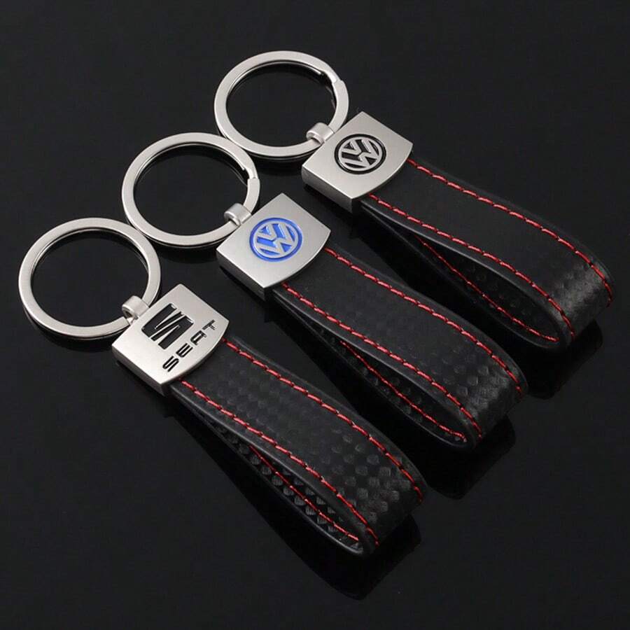 Gantungan kunci Volkswagen ini terbuat dari kulit imitasi hitam dan menampilkan jahitan kontras merah yang mencolok, dengan desain yang terinspirasi oleh gaya interior mobil performa tinggi. - Gantungan kunci Volkswagen - View 1