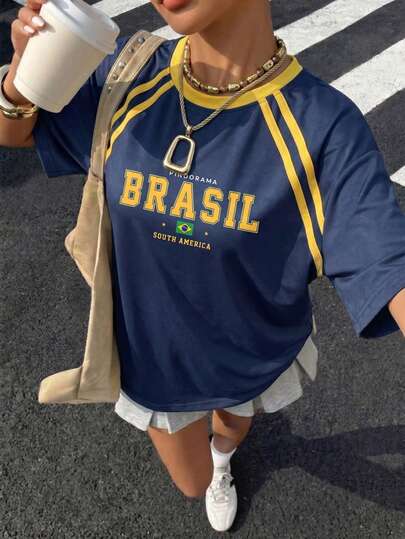 Áo thun thể thao dáng rộng màu xanh hải quân và vàng in chữ "BRASIL", kiểu dáng thường ngày lấy cảm hứng từ áo đấu Brazil thời kỳ Y2K, tay ngắn, thích hợp cho nữ mùa hè.
