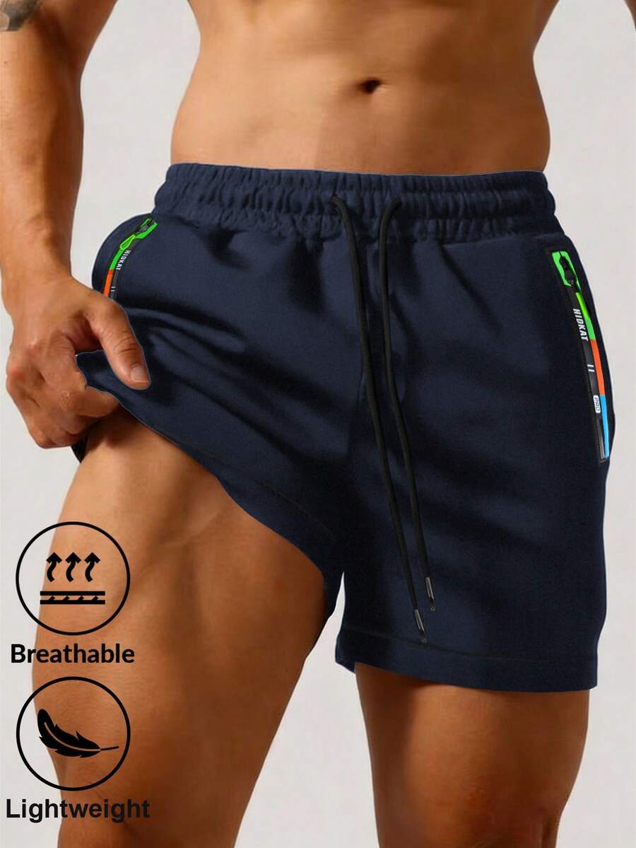 Pantalones cortos deportivos casuales negros para hombres con contraste de color lateral, bolsillos con cremallera, cintura con cordón, para verano
