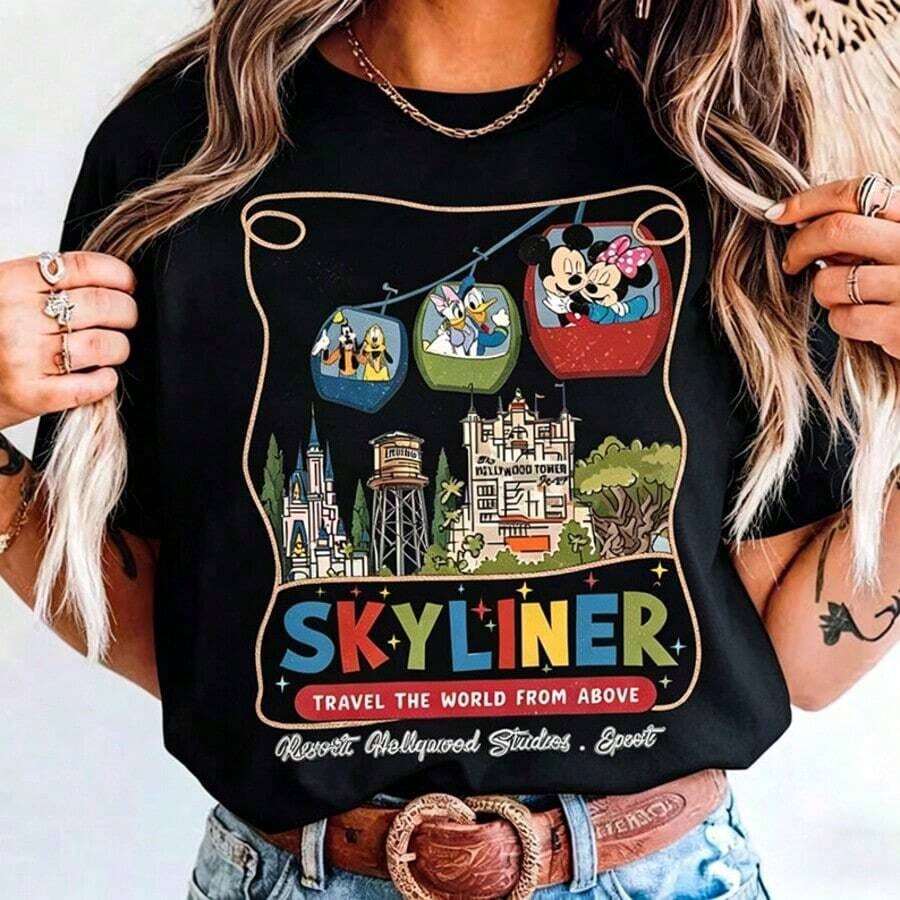 Authorized By Disney. Mickey Mouse) Disney SKYLINER Cable Car Theme, With Retro American Illustration Style On The Front, Presents The Cable Car Carrying Mickey, Minnie, Donald Duck, Daisy, Goofy And Bruto, And Below Is The Iconic Building Of Disneyland-Cinderella Castle, With Slogans Skyliner And TRAVEL THE WORLD FROM ABOVE, A Group Of Elegant Ladies And Ladies' Pure Cotton T-Shirts. The Fabric Is Soft, Comfortable And Breathable, Suitable For Daily Wear, Shopping, Travel, Parties And Home Use. Men's And Women's Clothing, As Well As Lovers' Clothing, Are Also Suitable As Exquisite Gifts. Every Woman Should Have One. - màu đen - Xem 1