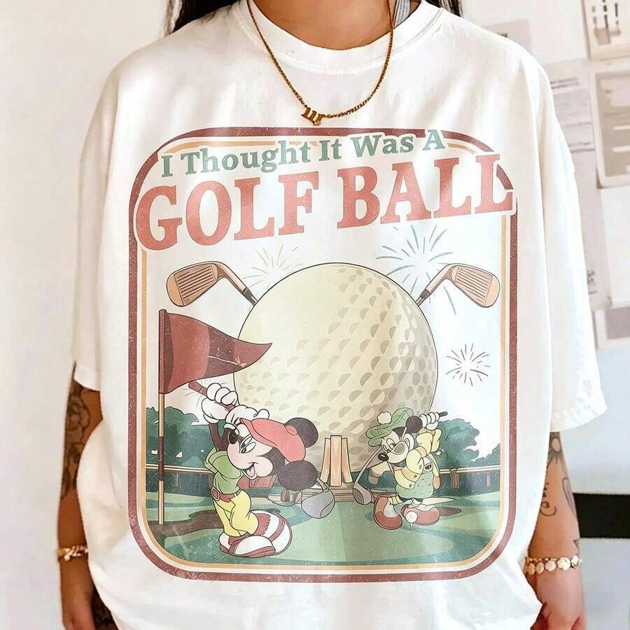 Authorized By Disney. Mickey Mouse Presents Mickey Playing Golf In American Retro Illustration Style, Mistakenly Thinking Epcot's Globe Is A Golf Ball, With The Slogan 'I Thought It Was A GOLF BALL', A Group Of Elegant Ladies And Ladies' Cotton T-Shirts. The Fabric Is Soft, Comfortable And Breathable, Suitable For Daily Wear, Shopping, Travel, Parties And Home Use. Men's And Women's Clothing, As Well As Lovers' Clothing, Are Also Suitable As Exquisite Gifts. Every Woman Should Have One. - trắng - Xem 1
