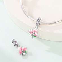 Một chiếc charm mạ bạc chủ đề hoa với thiết kế độc đáo kết hợp các yếu tố của hoa đào, hoa ly và hoa tulip. Mặt dây chuyền tráng men này được điểm xuyết bằng kim cương và có thể kết hợp với vòng tay hoặc dây chuyền. Là một phụ kiện làm trang sức tươi mới và thanh lịch, nó toát lên vẻ quyến rũ mềm mại và nữ tính, hoàn hảo cho cả các dự án DIY và đeo hàng ngày. - Nhiều màu - Xem 8