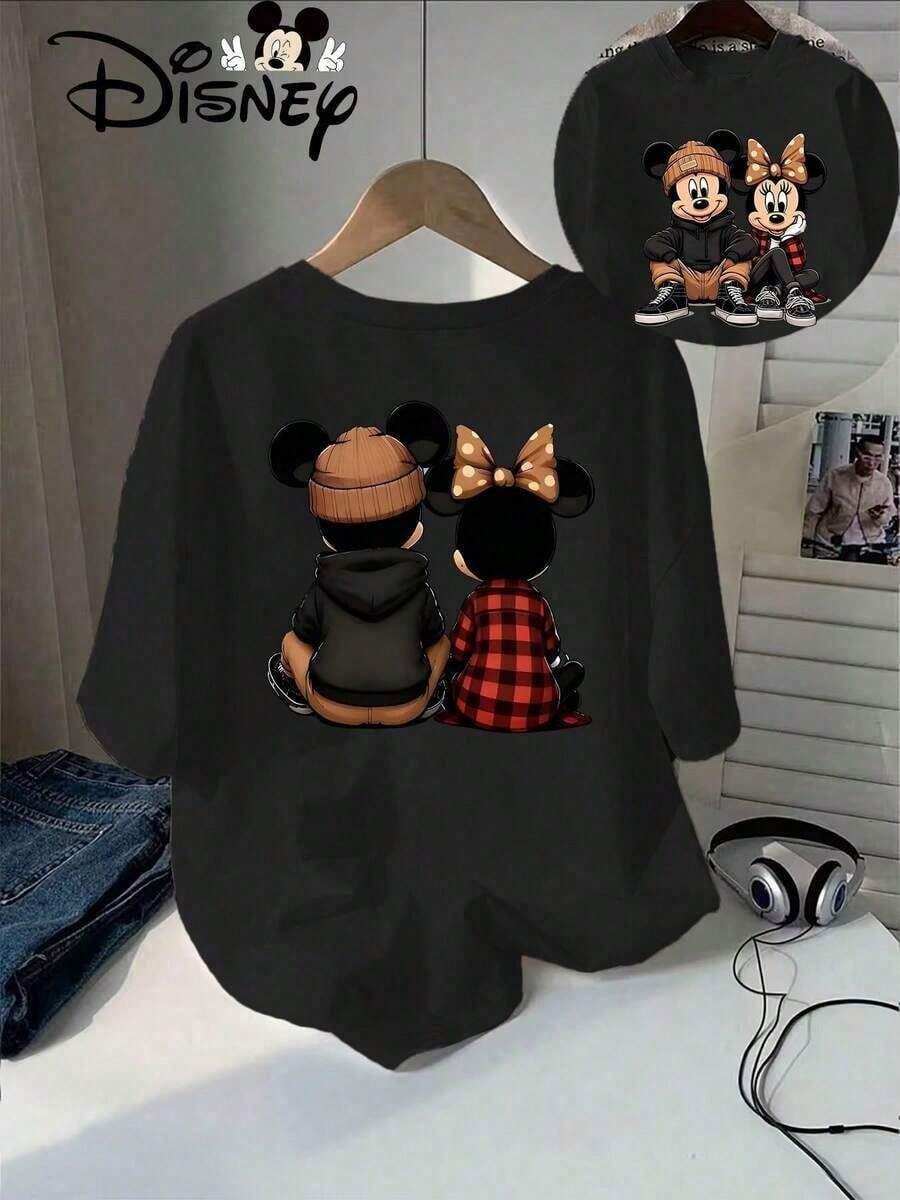 Disney Women's Fit T‑Shirt Is Officially Authorized By Disney. The Street‑Style Mickey & Minnie Front‑And‑Back Printed Women's T‑Shirt Adopts The Modern Casual Illustrated Design Featuring Front Full‑Body And Back Back‑View Mickey And Minnie Mouse In Hip‑Hop Winter Outfits With Beanie, Hoodie And Red Plaid Elements. The Short‑Sleeved Round Neck Casual Shirt Is Suitable For Spring And Autumn Wear, And The Fabric Is Soft And Breathable, Suitable For Couple Wear And Daily Wear. - Black - View 1