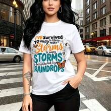 Camiseta de mujer con estampado de chica con cabello largo y ondulado en calle urbana bajo la lluvia - diseño con texto colorido "I've survived the Storms" y mariposas, ajuste casual cómodo y elegante con estilo urbano inspirador - ideal para salidas - Blanco - Ver 1