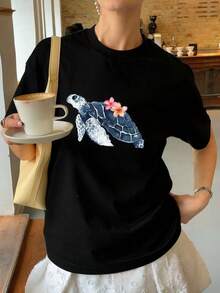 Camiseta negra informal de talla grande para mujer con un bonito estampado de tortugas y flores, manga corta, cuello redondo, largo regular. - Negro - Ver 1