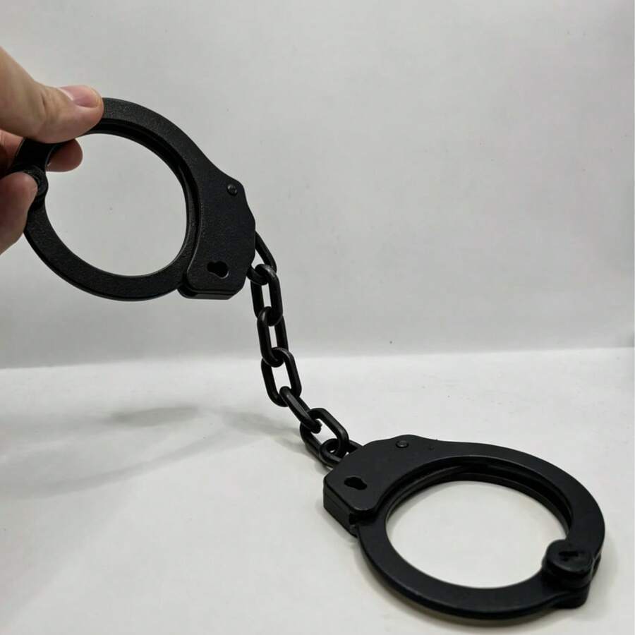 一套3D列印黑色塑膠手銬，設計成玩具外觀，附配套鑰匙，非常適合趣味角色扮演道具與派對裝飾，塑膠材質，具獨特鎖定機制