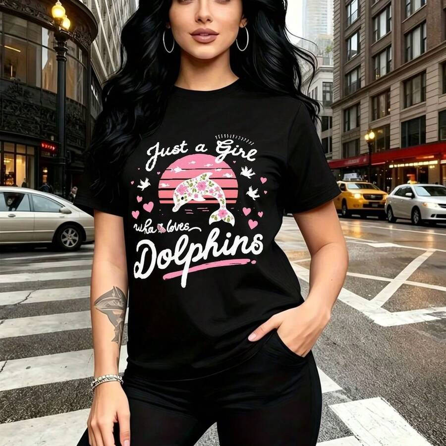 Camiseta de mujer con estampado de delfín saltando atardecer rosa y corazones - "Just a Girl who loves Dolphins" en letras cursivas y bold, diseño divertido y con personalidad, ajuste casual cómodo y fresco - ideal para paseos por la ciudad, salidas - Negro - Ver 1