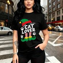 Camiseta de mujer con estampado navideño de sombrero de elfo y texto "THE ELF AT! CAT LOVER" sobre fondo verde - camiseta casual de manga corta con diseño festivo de calcetines rayados y huellas, ajuste cómodo y fresco ideal para paseos urbanos y sal - Negro - Ver 1