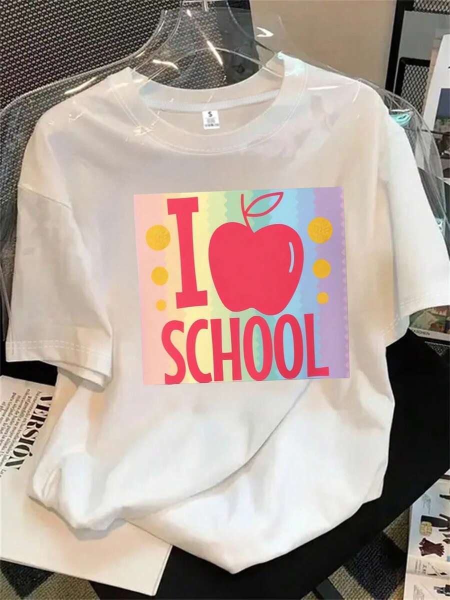 Camiseta de manga corta y cuello redondo para mujer con la imagen de una manzana y la frase "Me gusta la escuela" escrita en ella. El estampado es adecuado para todas las estaciones. - Blanco - Ver 1