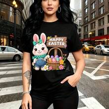 Camiseta de mujer con estampado festivo de conejito de Pascua con overol azul y bufanda verde junto a canasta de huevos pastel - camiseta casual de manga corta, ajuste cómodo y elegante, estilo urbano y alegre - ideal para celebraciones de Semana San - Negro - Ver 10