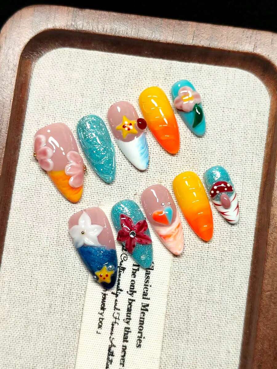 Vernis à ongles à presser fait main en rose nude avec des bords français orange, bleu et blanc, des fleurs gravées 3D rose et blanc, des étoiles de mer en relief, des formes de cœur et des motifs de champignons rouges, des paillettes argentées, des perles dorées et blanches, et des diamants scintillants. Ongles