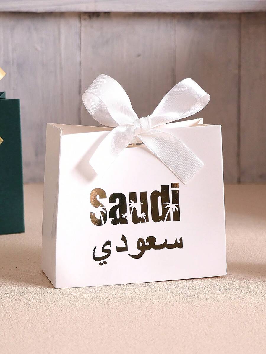 Saudi National Day Celebration Essential Paper Gift Box, Deep Green Background With Gold Foil Stamped "Saudi" And Arabic Text, Luxurious And Elegant. Made Of High-Quality Cardboard, Sturdy Box Shape, Paired With Yellow-Green Ribbon Bow, Exquisite And Beautiful. Specially Designed For National Day Reception, Souvenirs, Perfect For Saudi National Day Theme Party Decoration