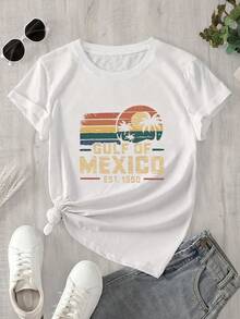 Esta camisa de manga corta y cuello redondo para mujer, fabricada fuera de México, presenta un logotipo de una palmera y un estampado de una puesta de sol sobre el fondo, ideal para todas las estaciones. - Blanco - Ver 1
