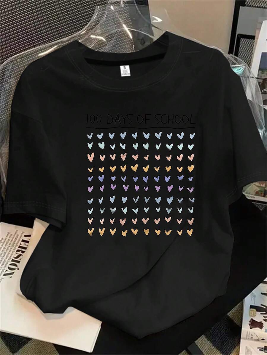 Camiseta de manga corta con cuello redondo para mujer, de fondo blanco, con corazones y palabras en rojo. Camiseta estampada con temática de los 100 días de clases, ideal para todas las estaciones. - Negro - Ver 1