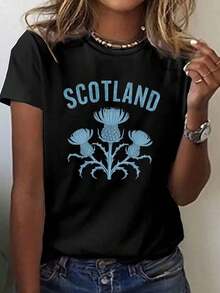 This Women's Short Sleeve Tee Is Made In And Features A Retro Y2K Style Slogan That Reads "Scotland" And A Motif Of Scotland's National Flower KGOU - Black - View 1
