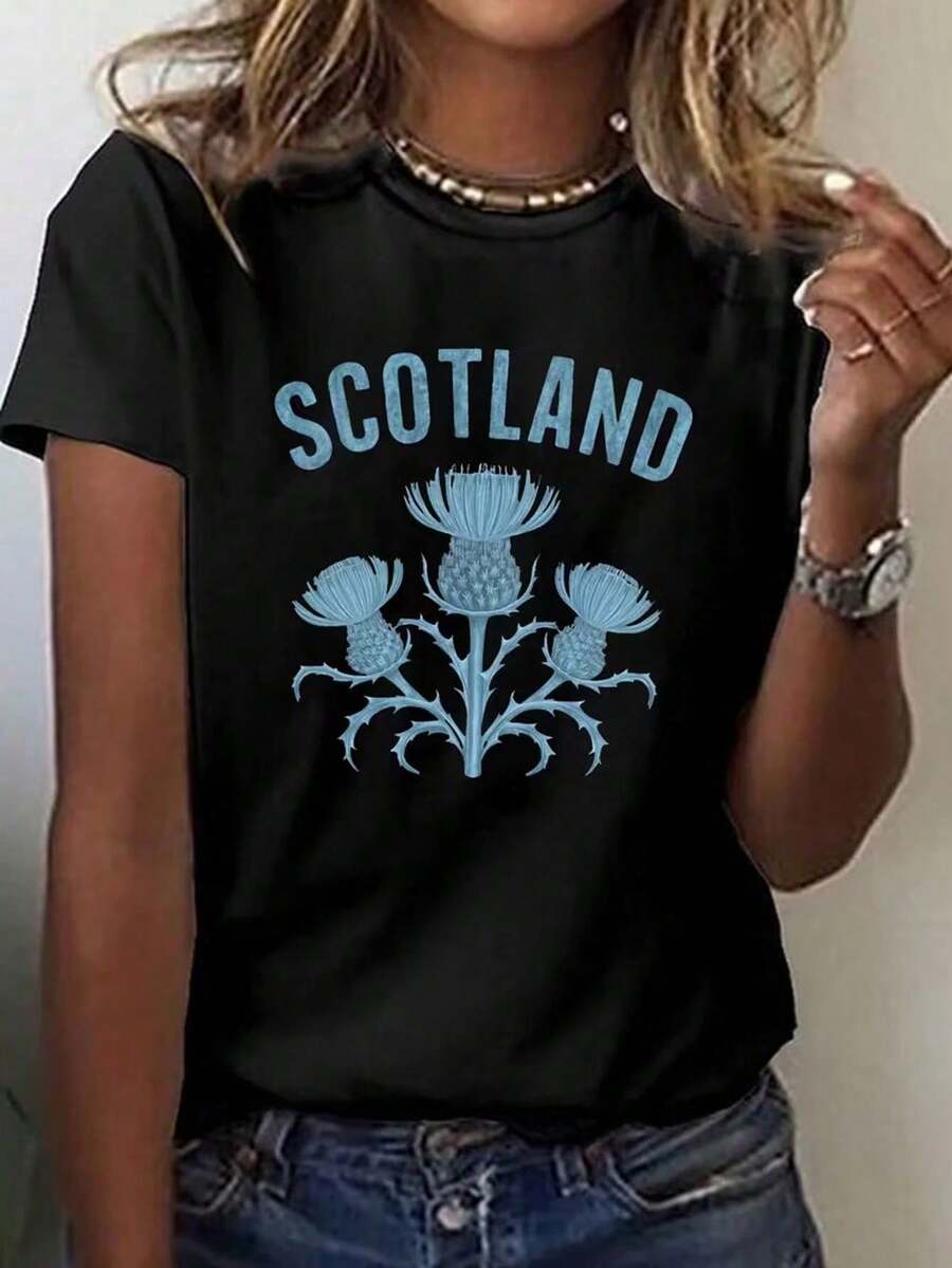 This Women's Short Sleeve Tee Is Made In And Features A Retro Y2K Style Slogan That Reads "Scotland" And A Motif Of Scotland's National Flower KGOU - Black - View 1