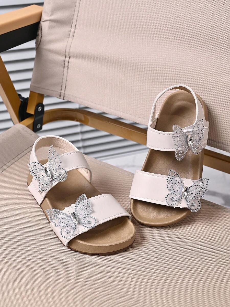 1 par de sandalias planas de niña con decoración de mariposa de strass brillante, punta abierta, correa de tobillo ajustable con cierre de gancho y bucle, suela blanda antideslizante, estilo princesa casual de verano para playa, adecuadas para salidas diarias - Rosa Pálido - Ver 1