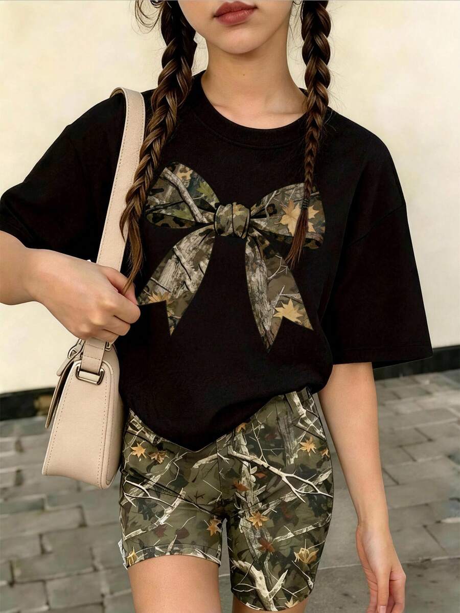 這套休閒套裝專為大童設計,包含一件杏色圓領T恤,印有創意漸層蝴蝶結圖案,搭配一件滿版樹枝圖案短褲。 - 黑色 - 查看 1