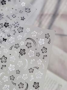 1 feuille d'autocollants pour ongles à motif floral nacré. Présentant des motifs de fleurs à cinq pétales noires et blanches avec un éclat iridescent, ces décalcomanies pour ongles auto-adhésives sont des accessoires parfaits pour le nail art DIY. - Multicolore - Voir 5