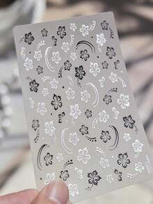 1 feuille d'autocollants pour ongles à motif floral nacré. Présentant des motifs de fleurs à cinq pétales noires et blanches avec un éclat iridescent, ces décalcomanies pour ongles auto-adhésives sont des accessoires parfaits pour le nail art DIY. - Multicolore - Voir 3