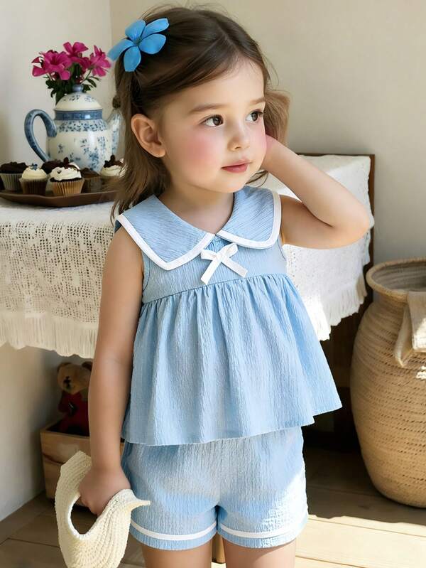 2 pièces/set Tenue de style scolaire douce pour jeunes filles, gilet à col marin bleu marine décoré d'un nœud mignon + short décontracté texturé de couleur unie, été