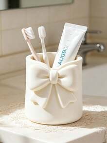 Mini Cream-Colored Bow-Shaped Creative Toothbrush Holder, Can Be Used As A Toothbrush Cup Or Desktop Storage Organizer. It Can Hold Toothbrushes, Toothpaste And Other Items. At The Same Time, It Can Also Be Used As A Flower Pot Or Vase To Add Decorative Effect To The Vanity, Making It An Ideal Choice Among Bathroom Supplies. Perfect For Creating A Warm Home Bathroom Atmosphere, And Also An Ideal Choice For Autumn Decor And Back To School Season. - Multicolor - View 1