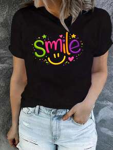 a casual y elegante presenta un colorido gráfico de 'Smile', con la letra 'I' diseñada creativamente como una cara sonriente amarilla, una adición elegante al guardarropa de cualquier mujer. - Negro - Ver 1