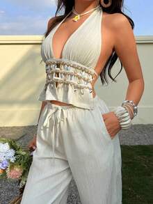 Conjunto de dos piezas con top halter de cuello en V profundo y textura arrugada en color albaricoque, y pantalones rectos de cintura baja. - Negro - Ver 6