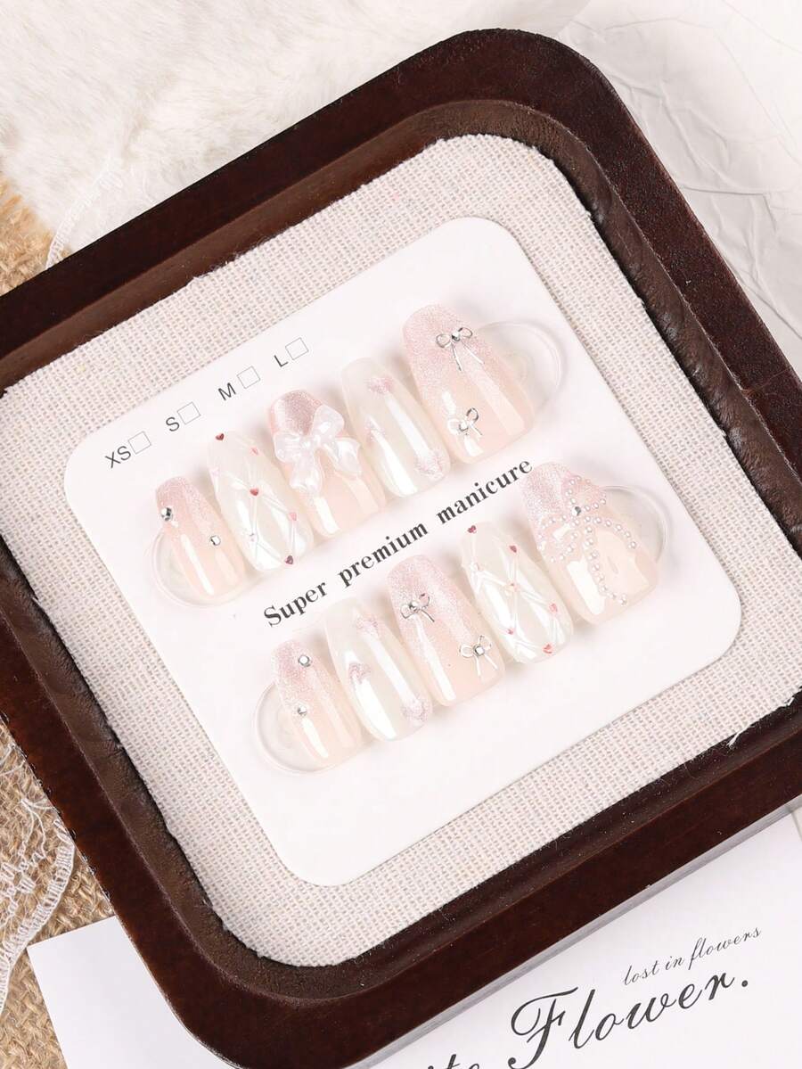 10片中長款棺材形手工穿戴甲，甜美女孩風漸層柔粉裸色亮片假指甲，飾有3D白色蝴蝶結、迷你銀色蝴蝶結、愛心水鑽與珍珠流蘇，適合夏季旅行搭配