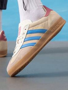 Adidas Originals 男女通用 GAZELLE INDOOR 舒適輕量休閒低筒綁帶滑板鞋，適合日常穿著、旅行與運動 - 岩層沙暴土/脈衝藍/粉白 - 查看 1
