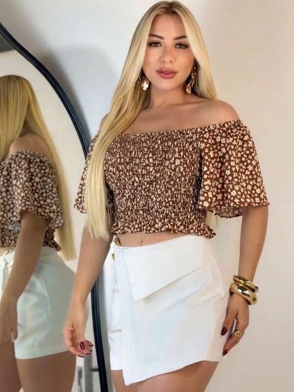 Blusa cropped feminina com estampa de leopardo, ombros à mostra, babados e mangas três quartos. Confeccionada em poliéster com elasticidade média.